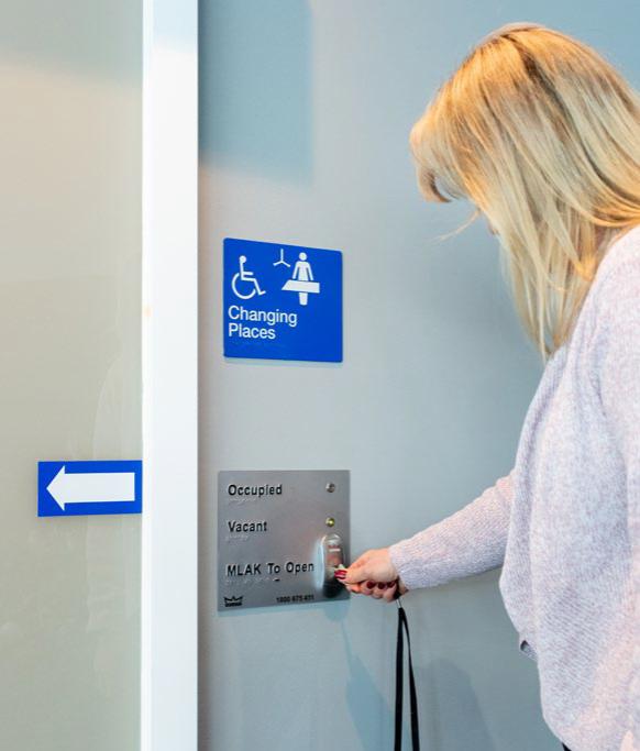 Changing Places, a women opening an accessible bathroom